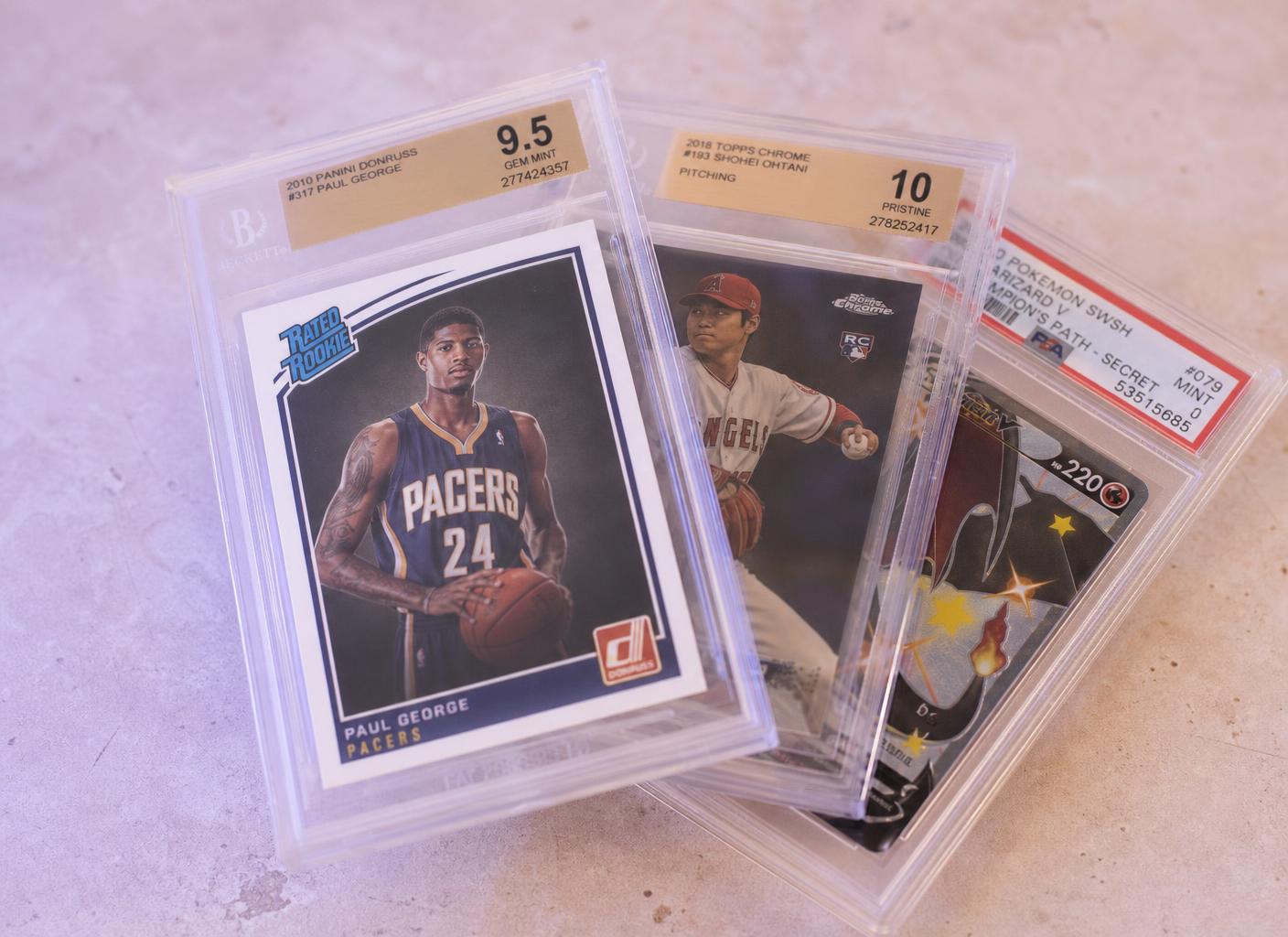 Row of professionally graded trading card slabs in secure storage